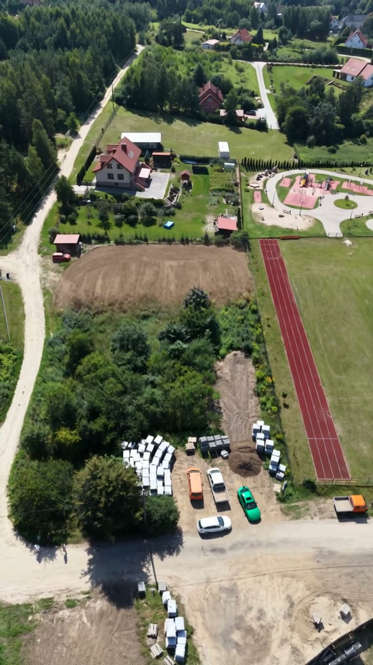 Działka pod zabudowę z wizualizacją domu — ujęcie z drona